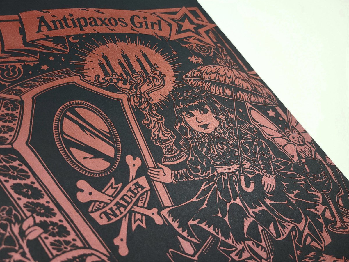 Decorative screen print with intricate design and text 'Antipaxos Girl' on a black background.
