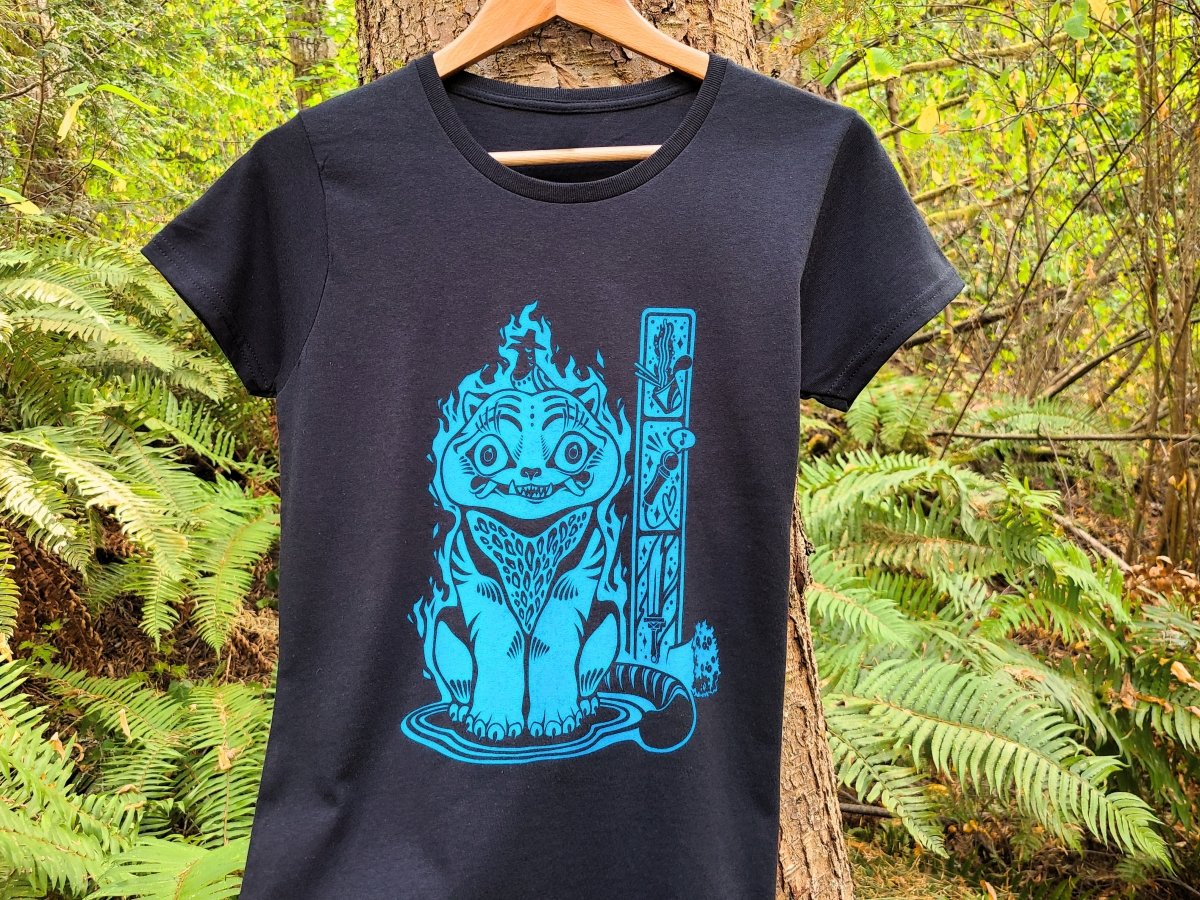 Black t-shirt with blue graphic design of Derpy Tiger hanging on a tree in a forest setting