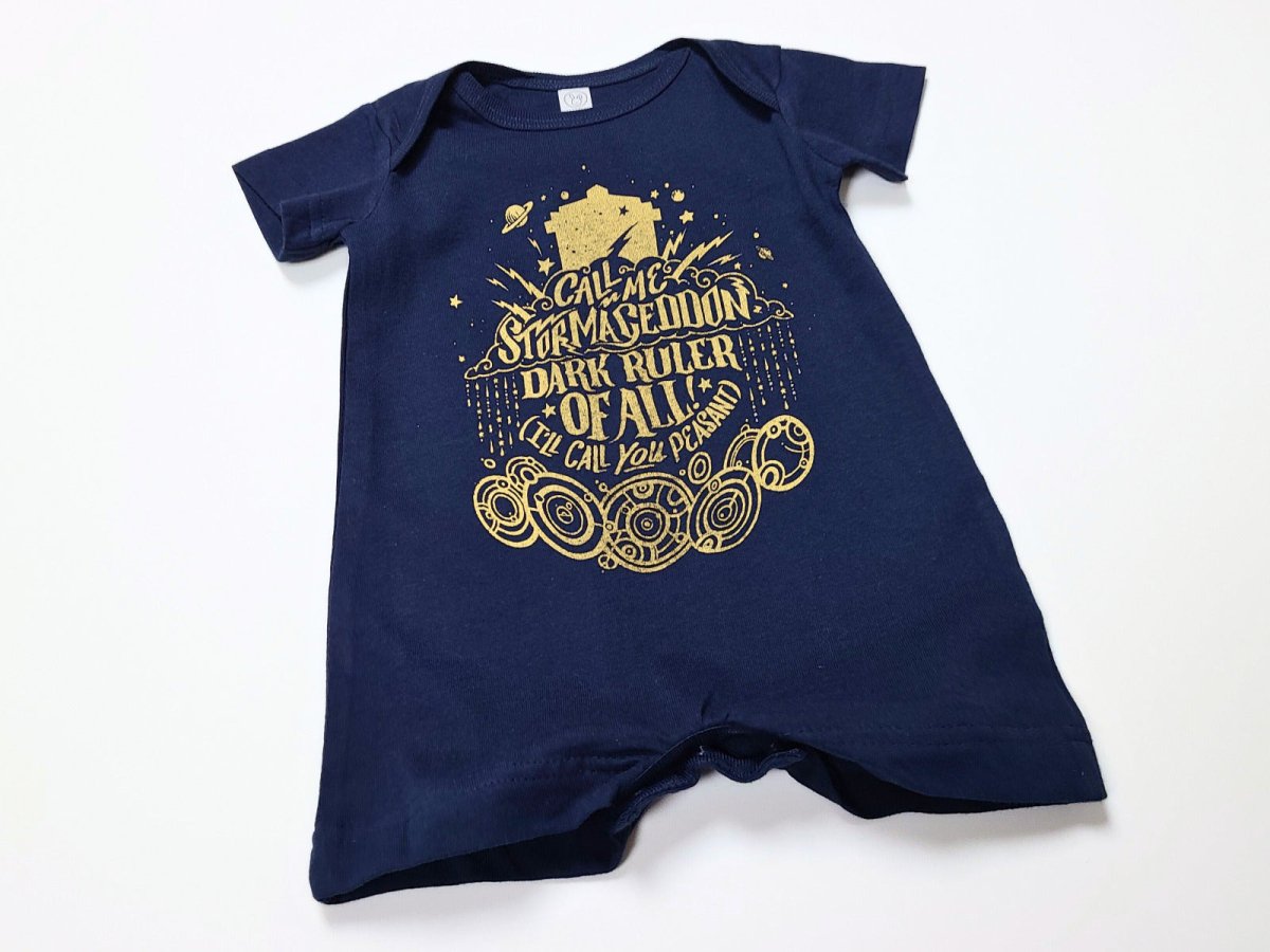 Navy blue baby romper with gold text and design on a white background