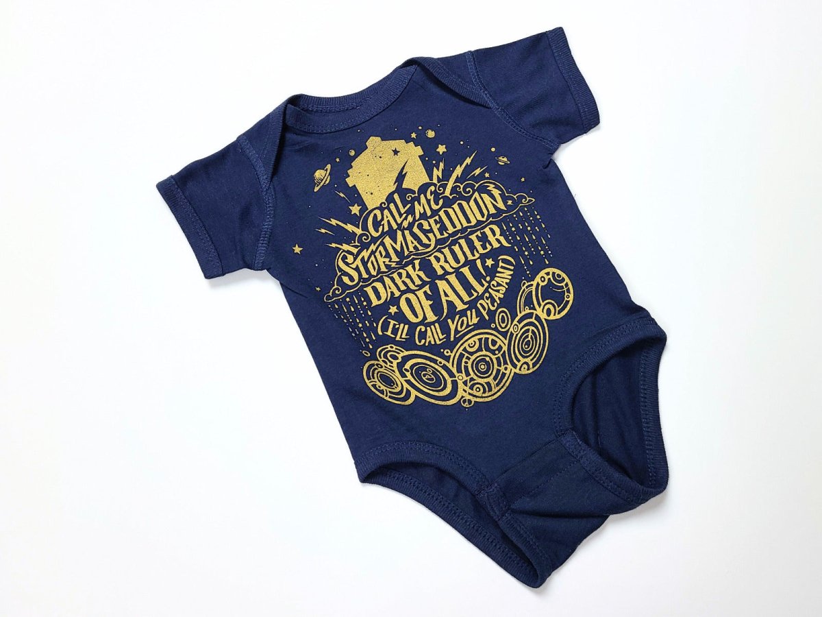 Navy blue baby onesie with gold text and graphics on a white background