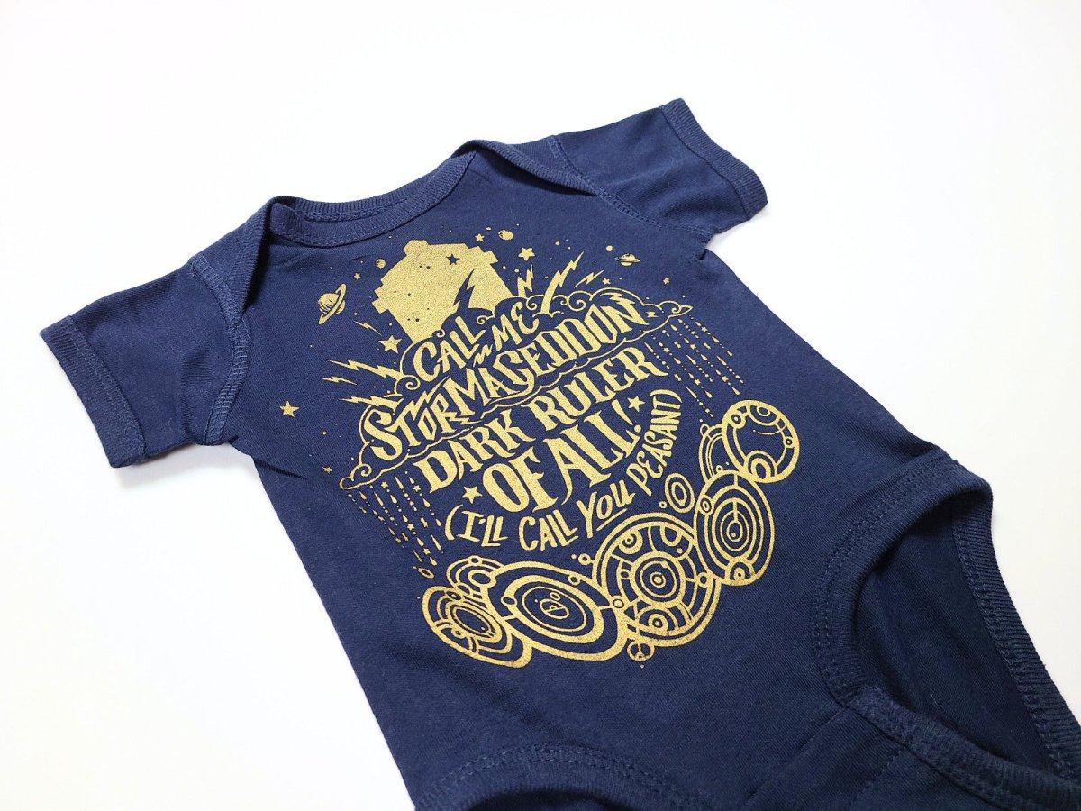 Navy blue baby onesie with gold graphic design on a white background